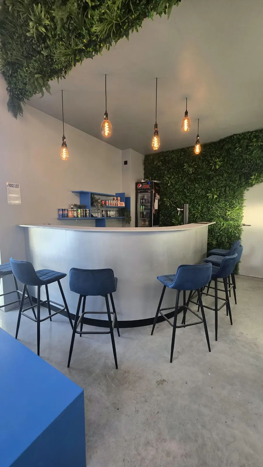 De bar van MTEC Games met hoge krukken en hangende lampen