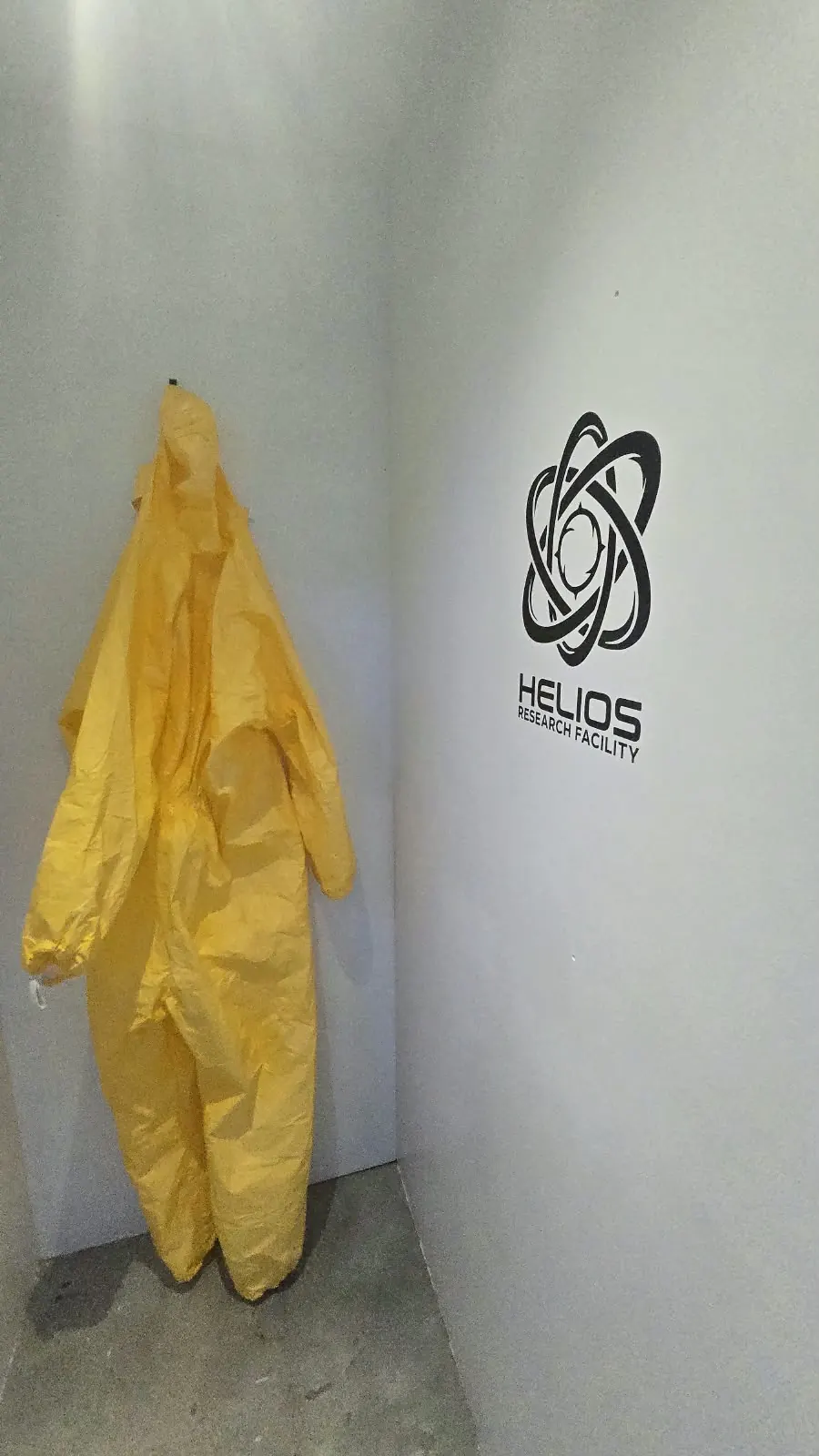 Geel beschermpak naast het Helios-logo